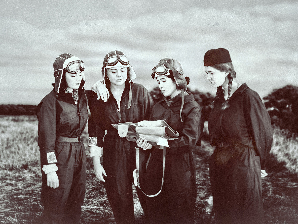Four female WWII Soviet aviators looking at navigation plans